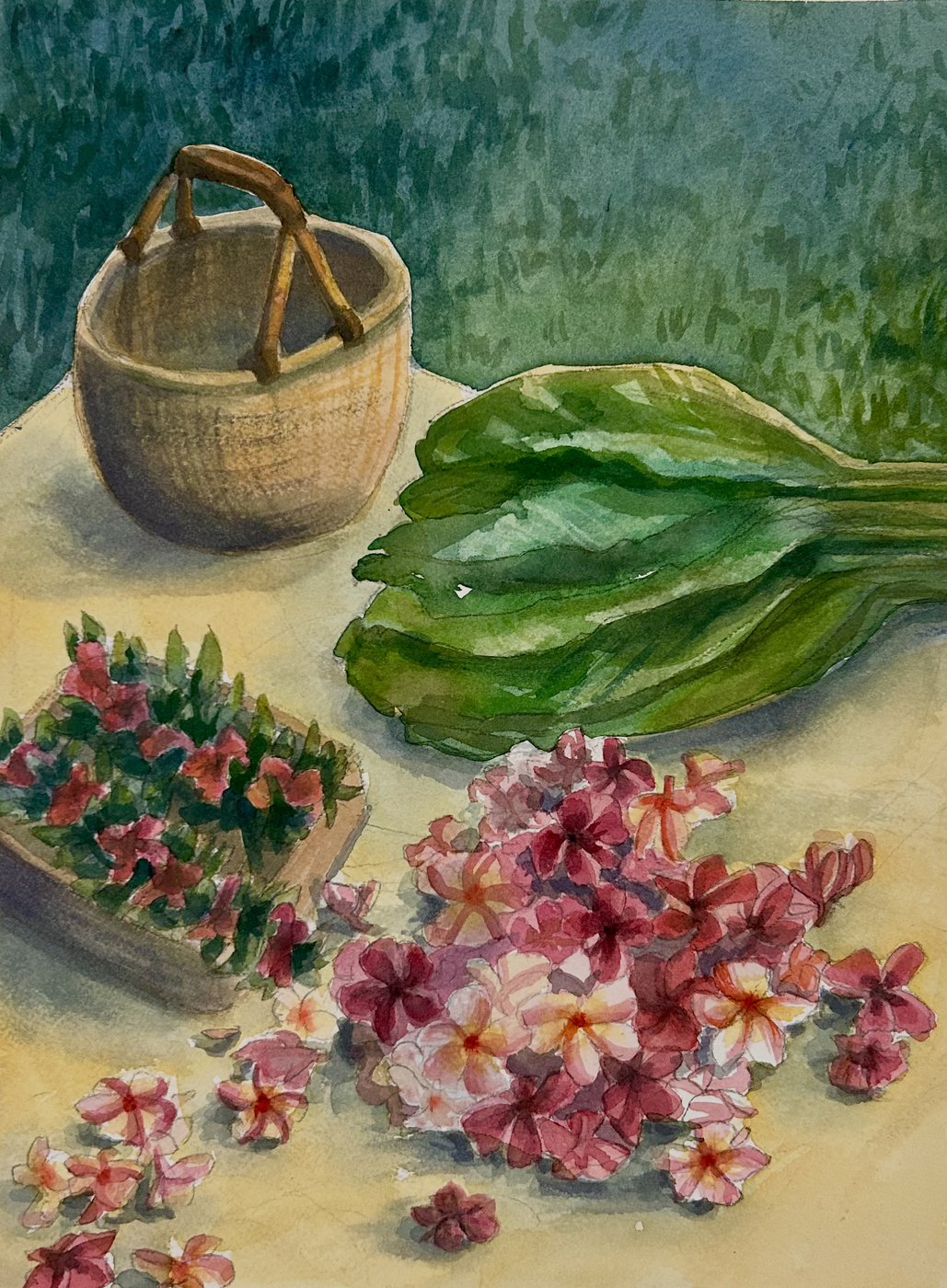 Watercolor still life of a woven basket, a bundle of large green leaves and pink and white plumeria blossoms on a pale yellow cloth